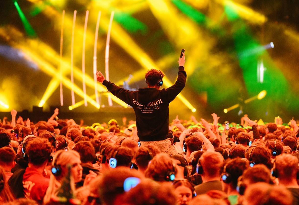 Boy on shoulders in a crowd with headphones on